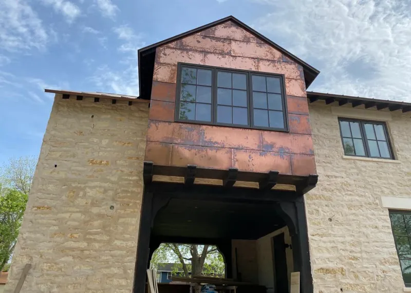 Copper metal panel facade on a stone building for Roof Repair in Winfield